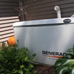 Generac generator outdoors by a building with star decoration and pumpkin, highlighting Cardinal Heating services.