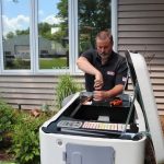 Man maintaining a hot tub outdoors, showcasing Cardinal Heating, Cooling, Plumbing & Electric services.