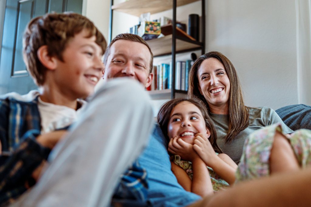 Family enjoying time together in a cozy living room, showcasing warmth and connection in a home setting.